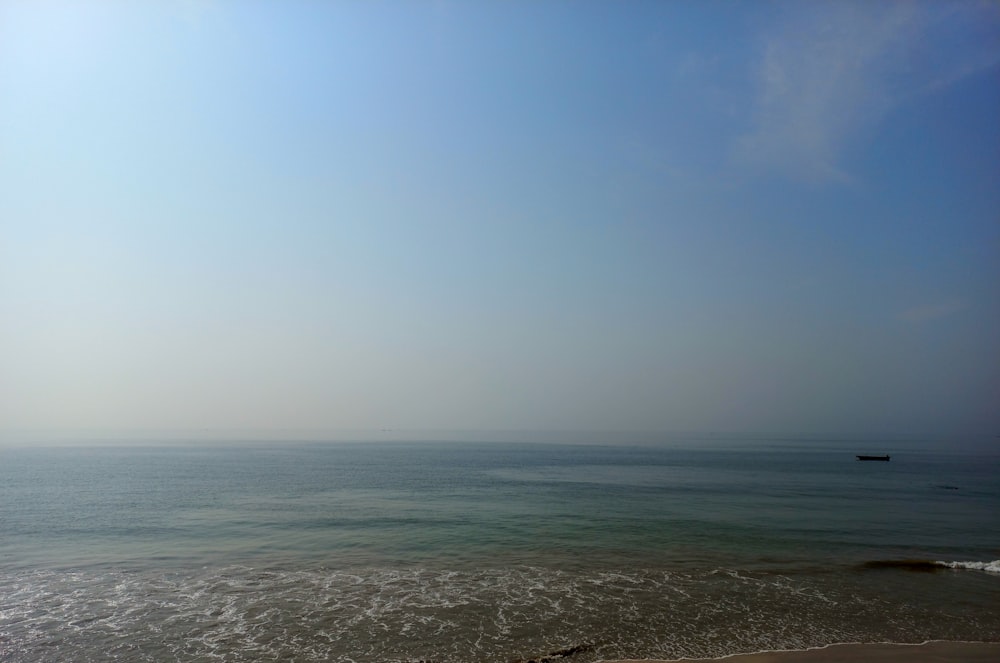 a boat is out on the ocean on a sunny day