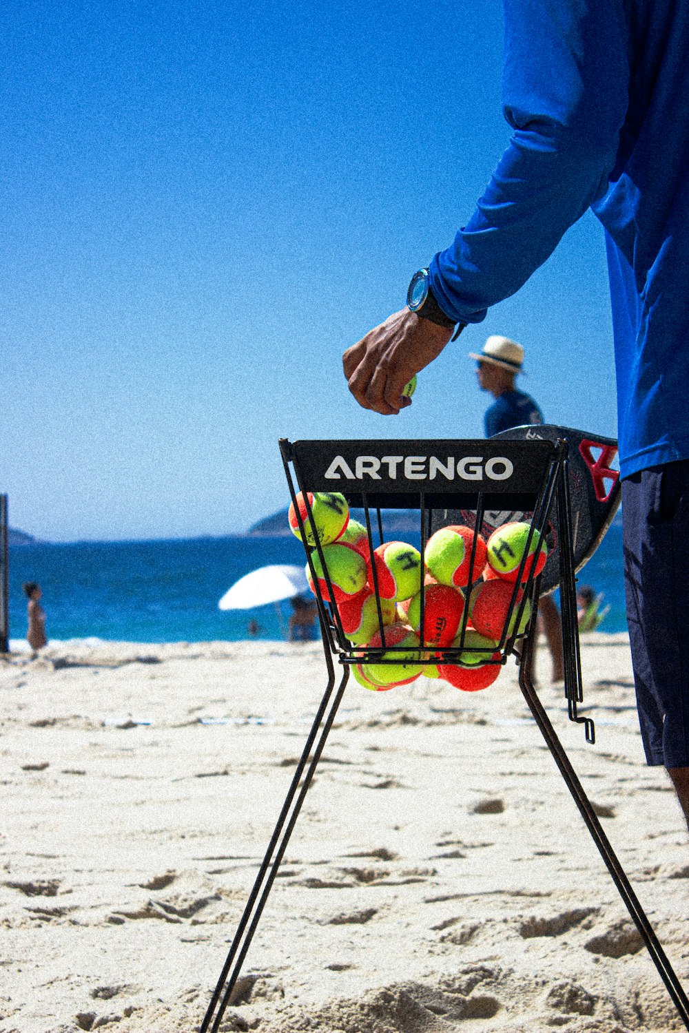 a man holding a rack with tennis balls in it