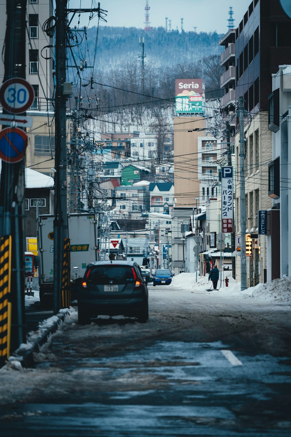 a car driving down a street next to tall buildings