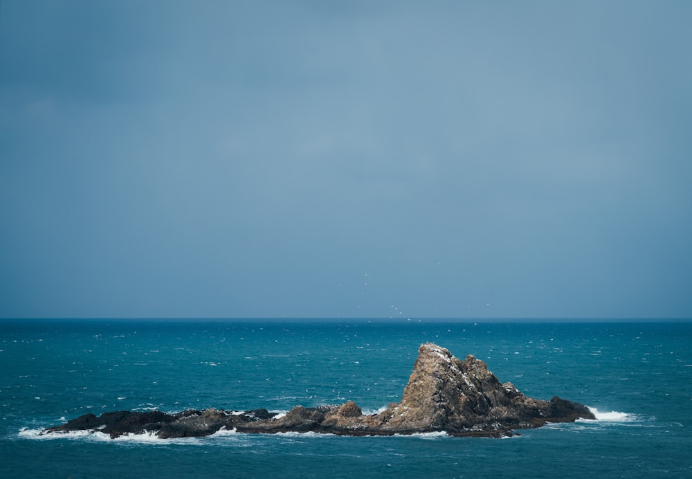 a large rock sticking out of the ocean