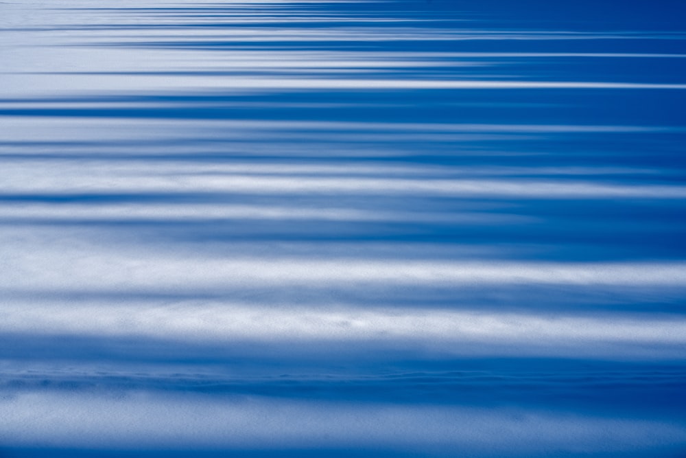 a large body of water with a sky in the background