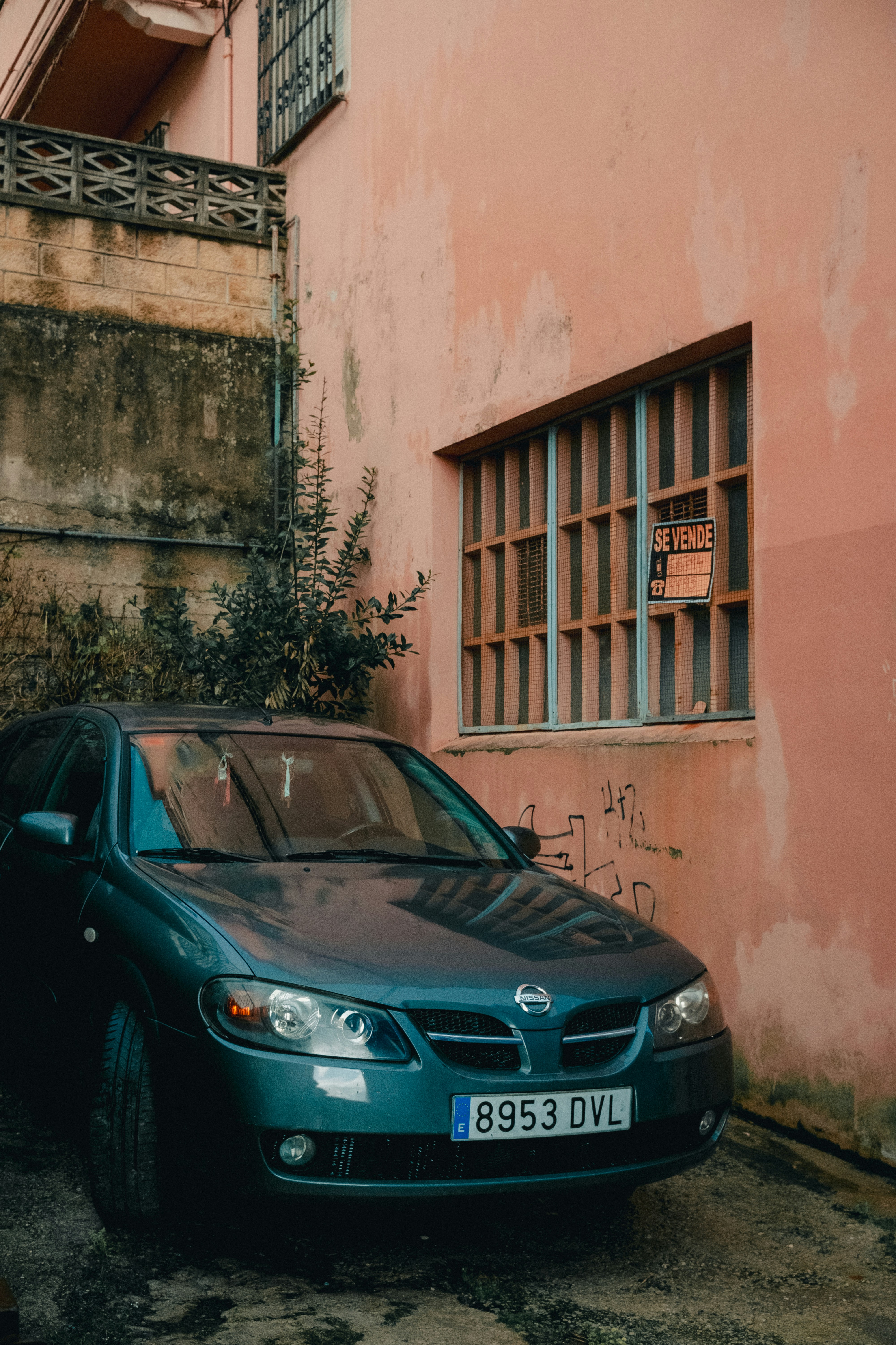 a car parked in front of a pink building