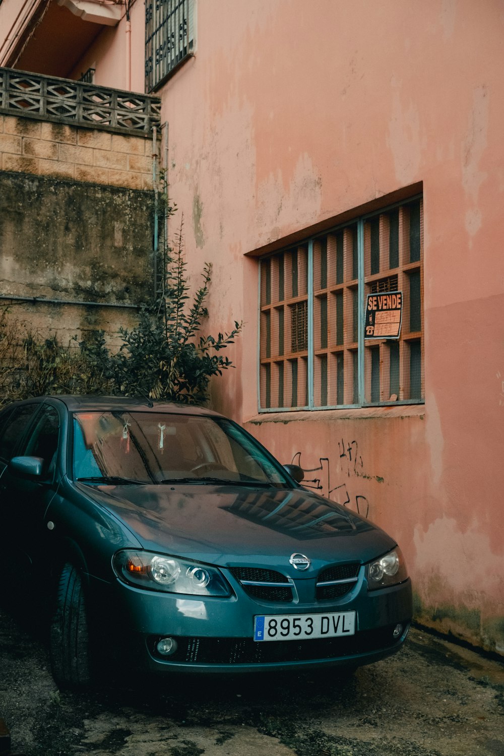 a car parked in front of a pink building