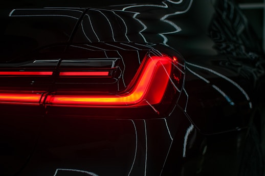 the tail lights of a black sports car