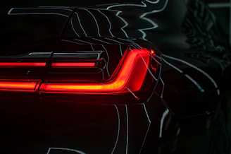 the tail lights of a black sports car