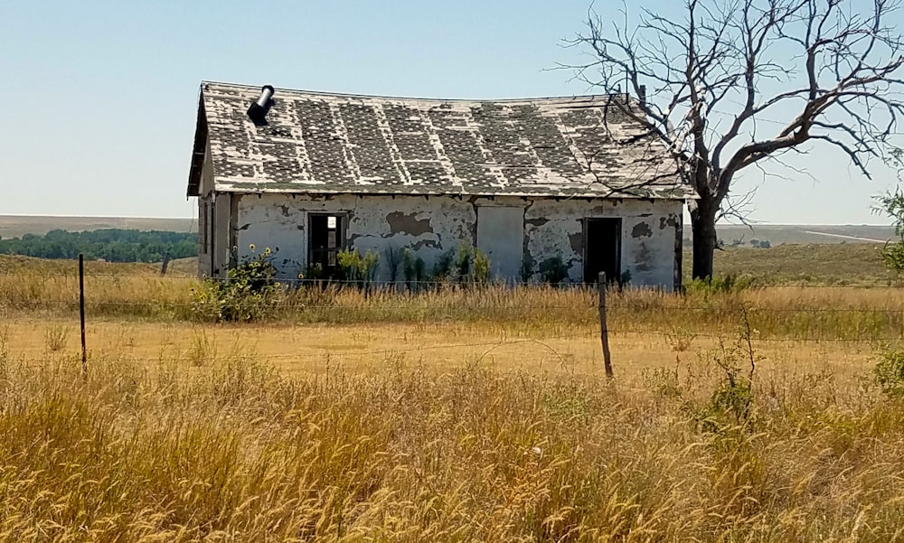 an old run down house sitting in a field