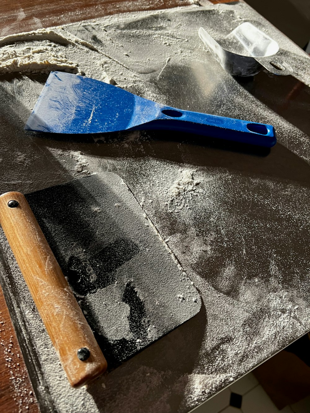 a blue spatula sitting on top of a wooden table