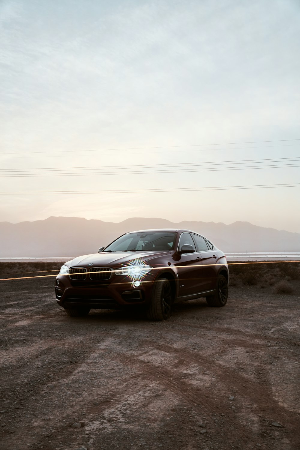 a brown car parked on a dirt road