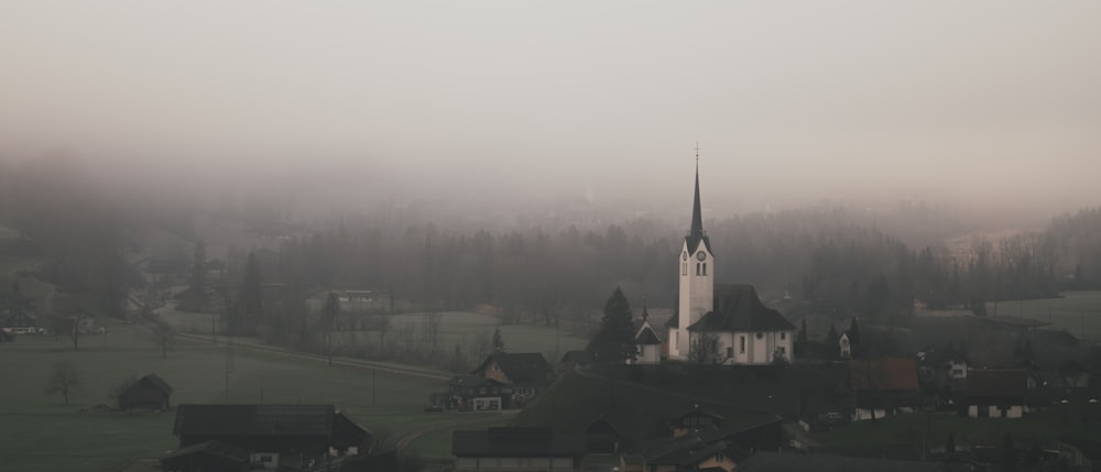 a foggy day with a church in the foreground