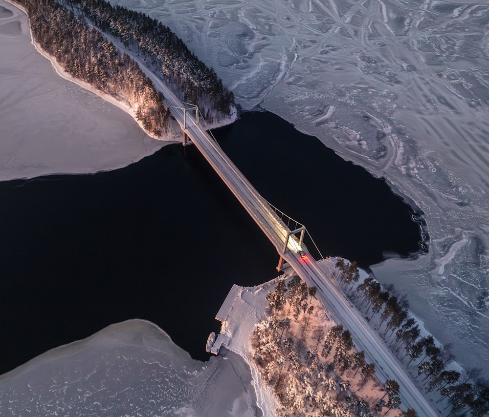an aerial view of a bridge in the snow
