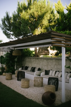 a white couch sitting under a wooden pergol