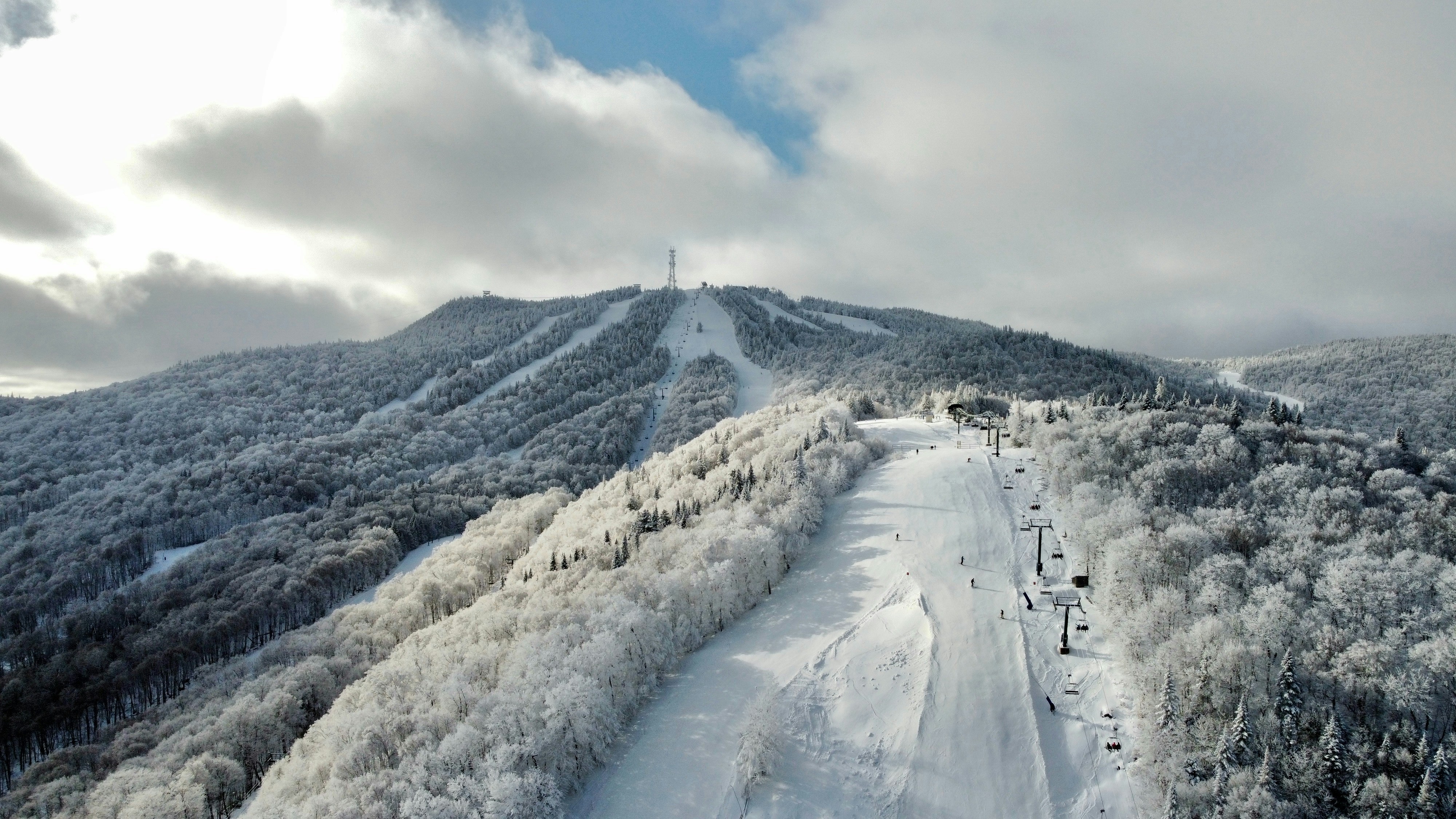a snow covered mountain with a ski lift on top of it