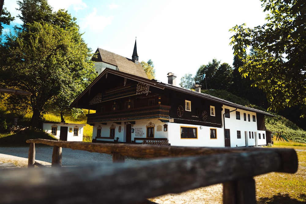 a white and brown house with a black roof