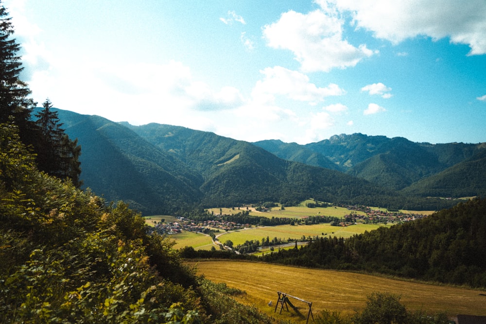 a scenic view of a valley with mountains in the background