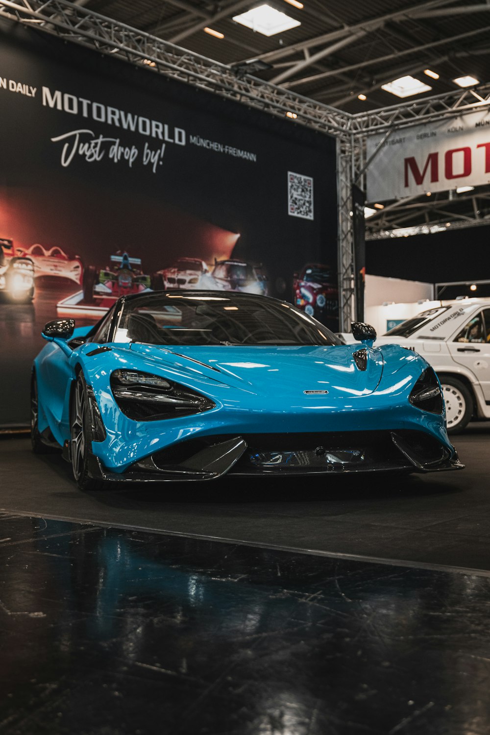 a blue sports car on display at a car show