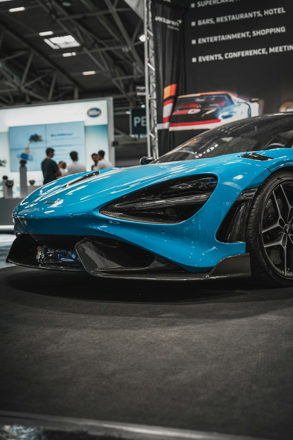 a blue sports car on display at a car show