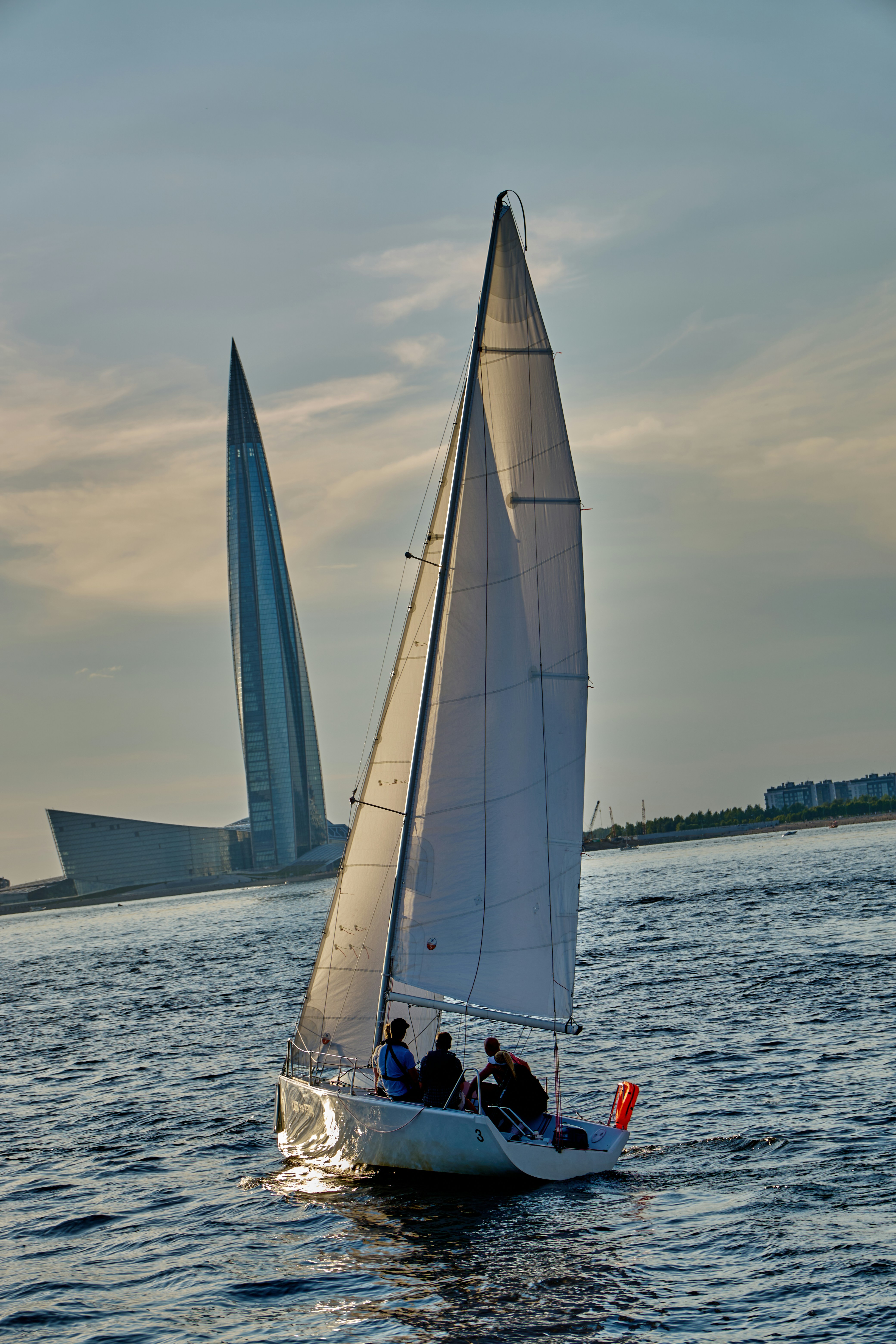 a sailboat with two people on it in the water