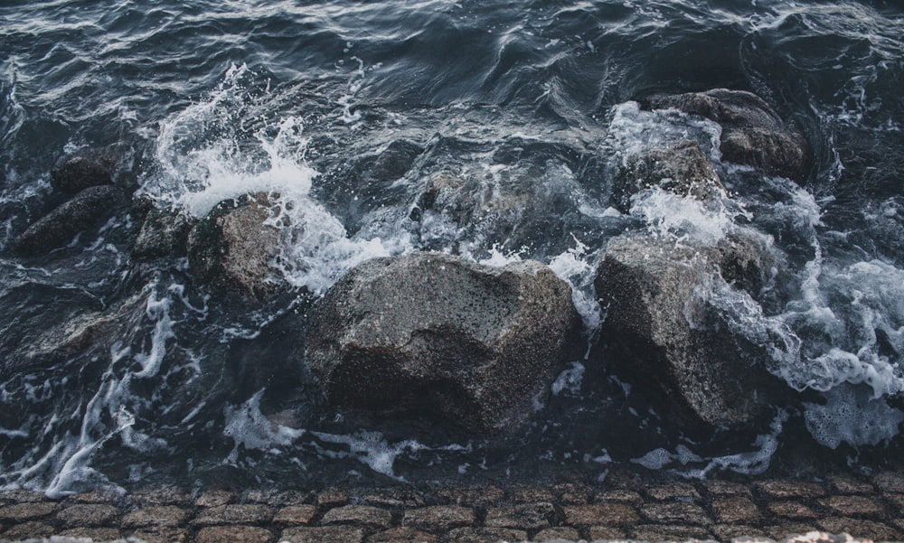 a group of rocks sitting on top of a body of water