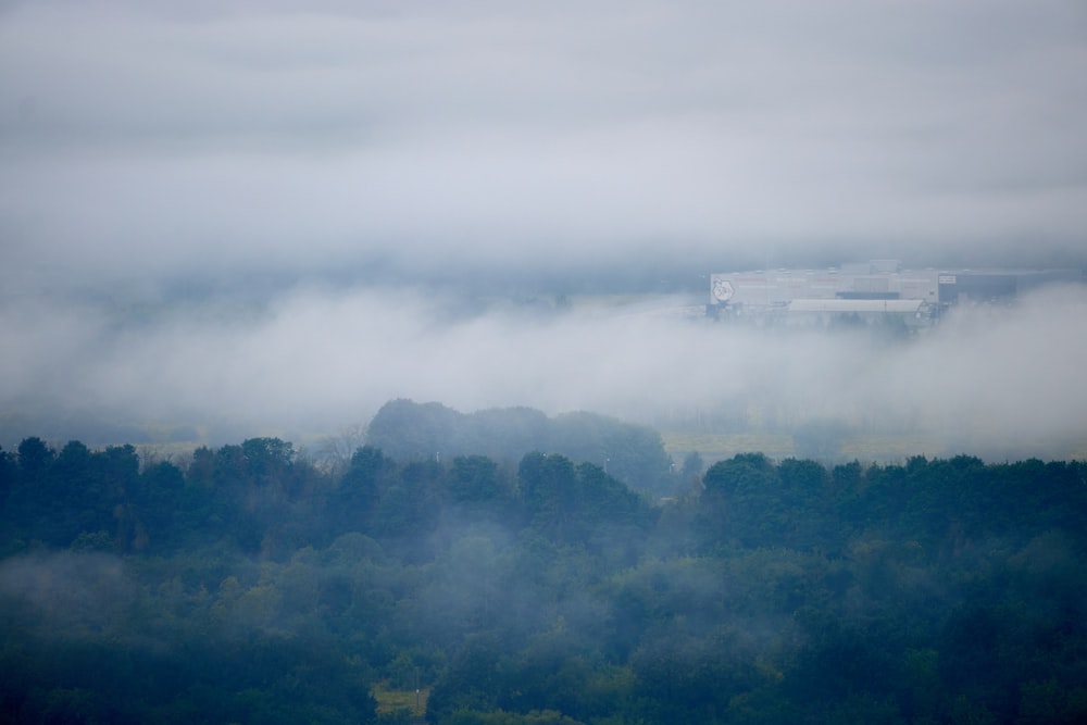 a foggy landscape with a building in the distance