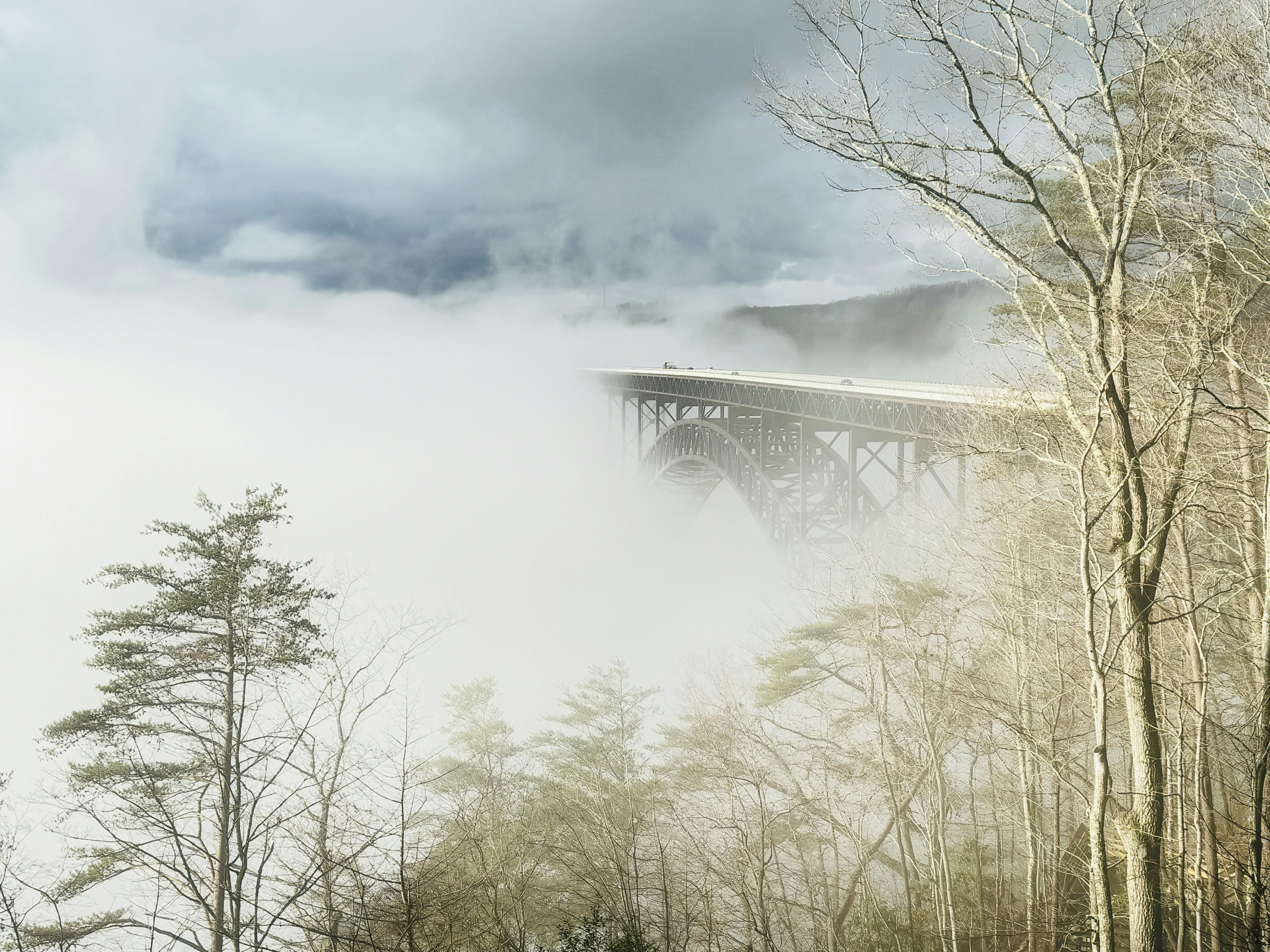 a train traveling over a bridge on a foggy day