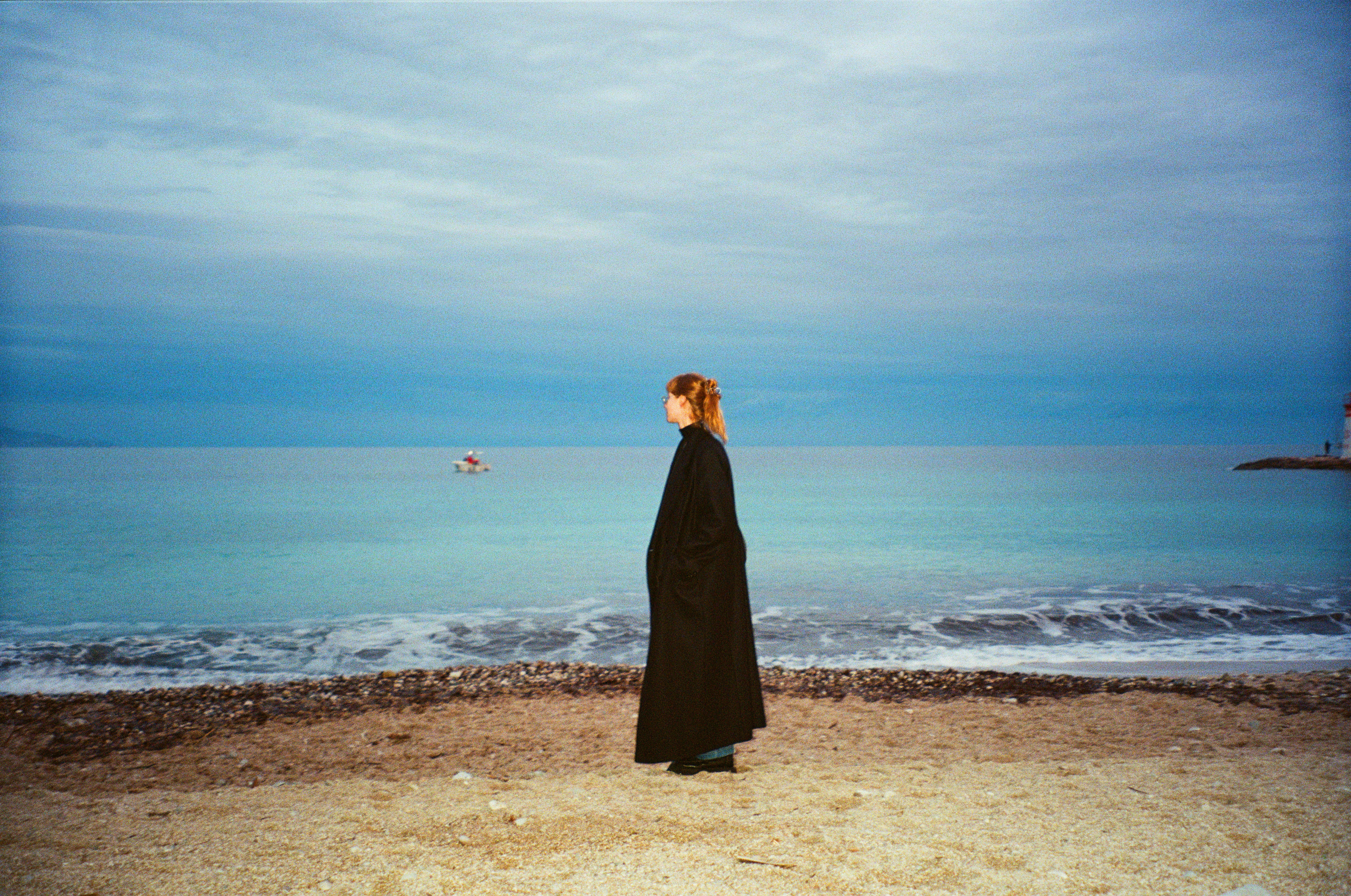 a woman standing on a beach next to the ocean