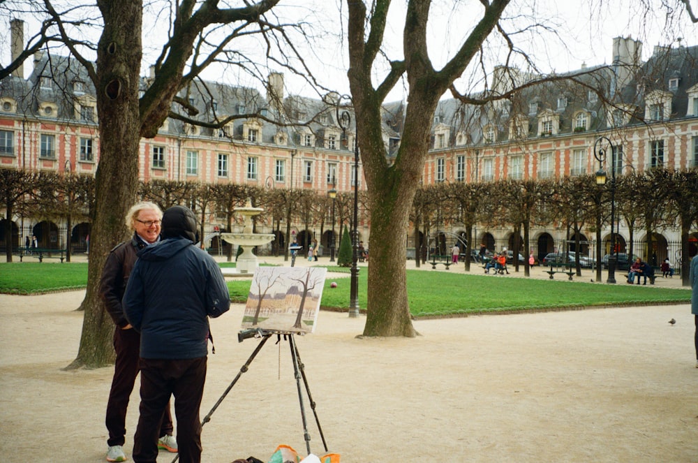 a man standing in front of a painting on a easel