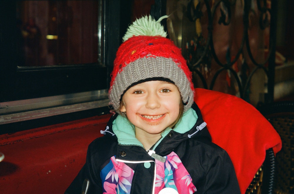 a young child wearing a hat and scarf