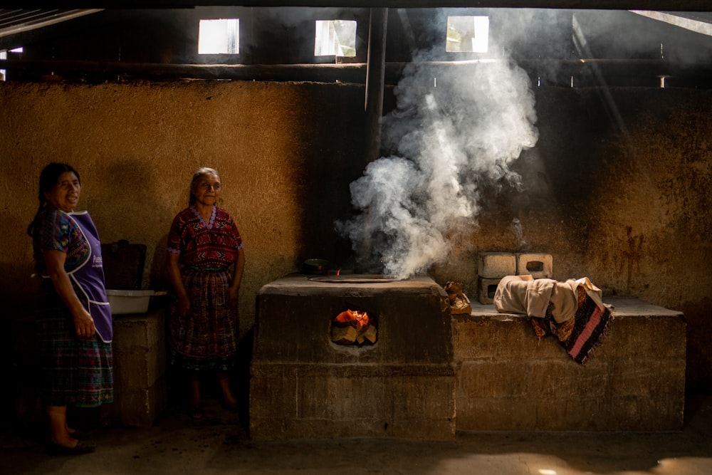 a couple of women standing next to a stove
