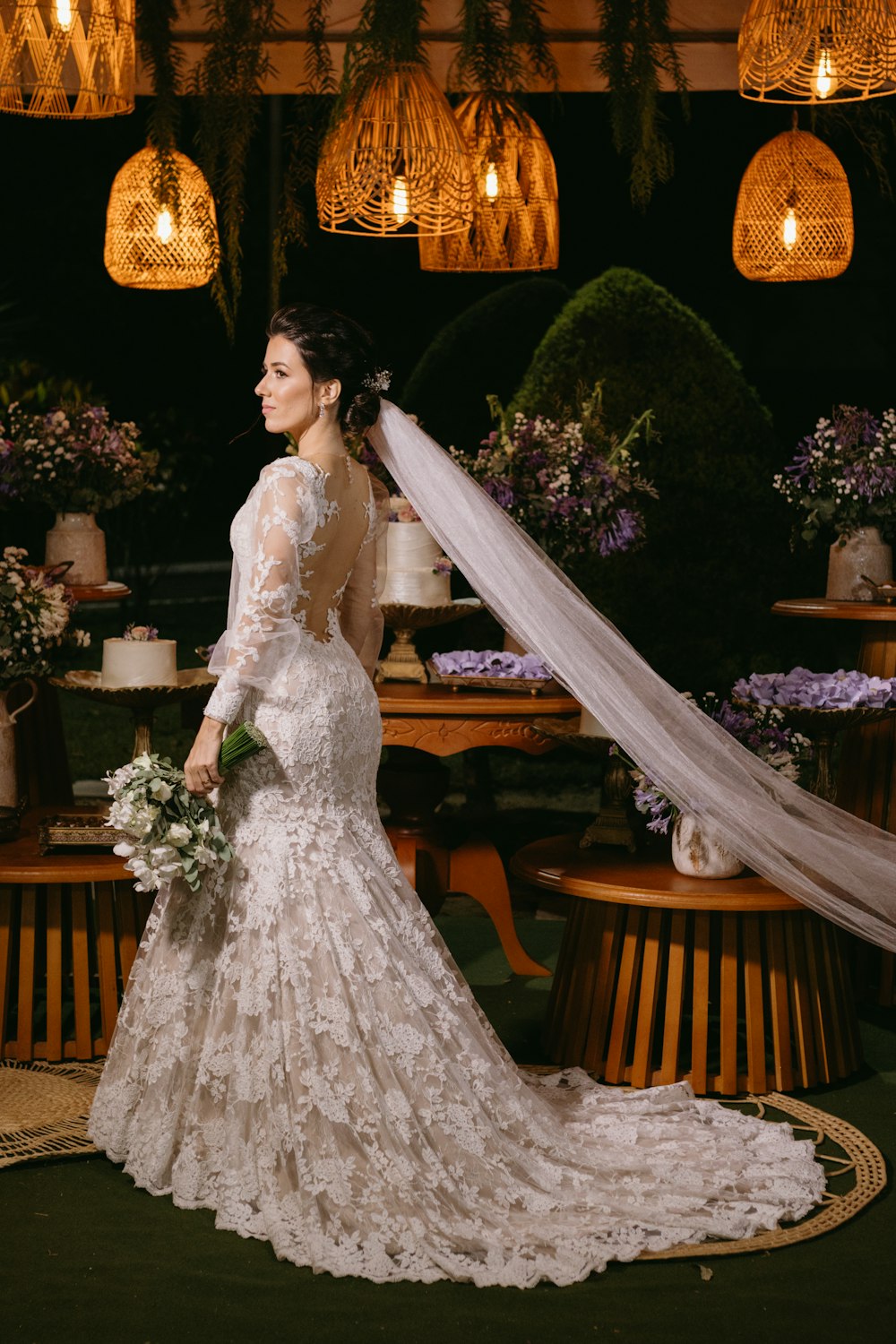 a woman in a wedding dress standing in front of a table