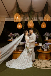 a bride and groom standing under a canopy