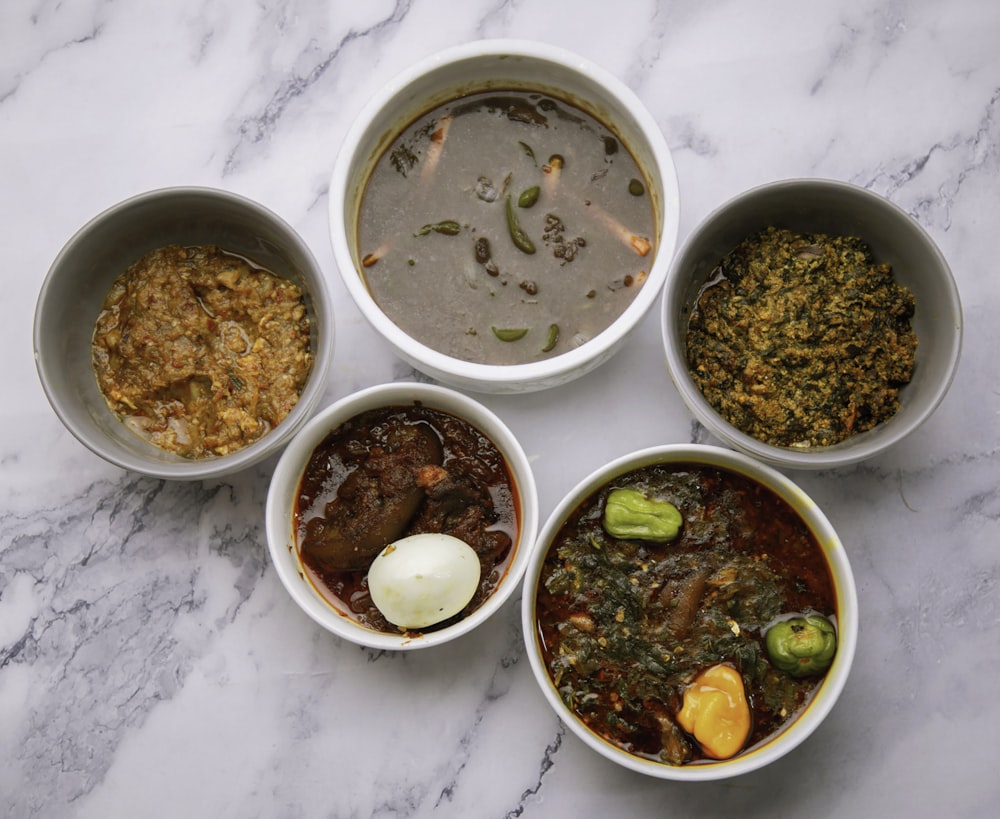 a table topped with four bowls of food