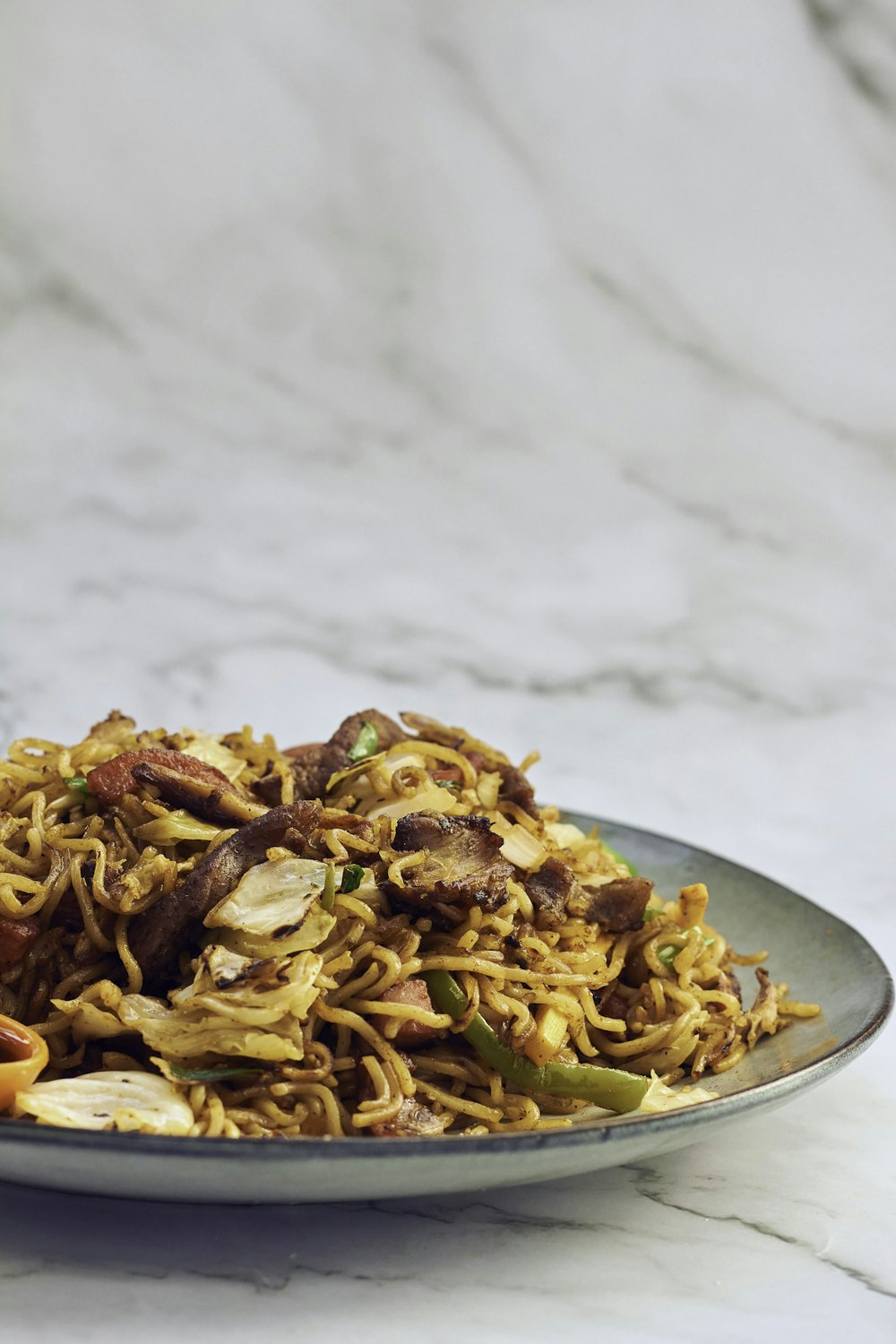 a plate of noodles with meat and vegetables