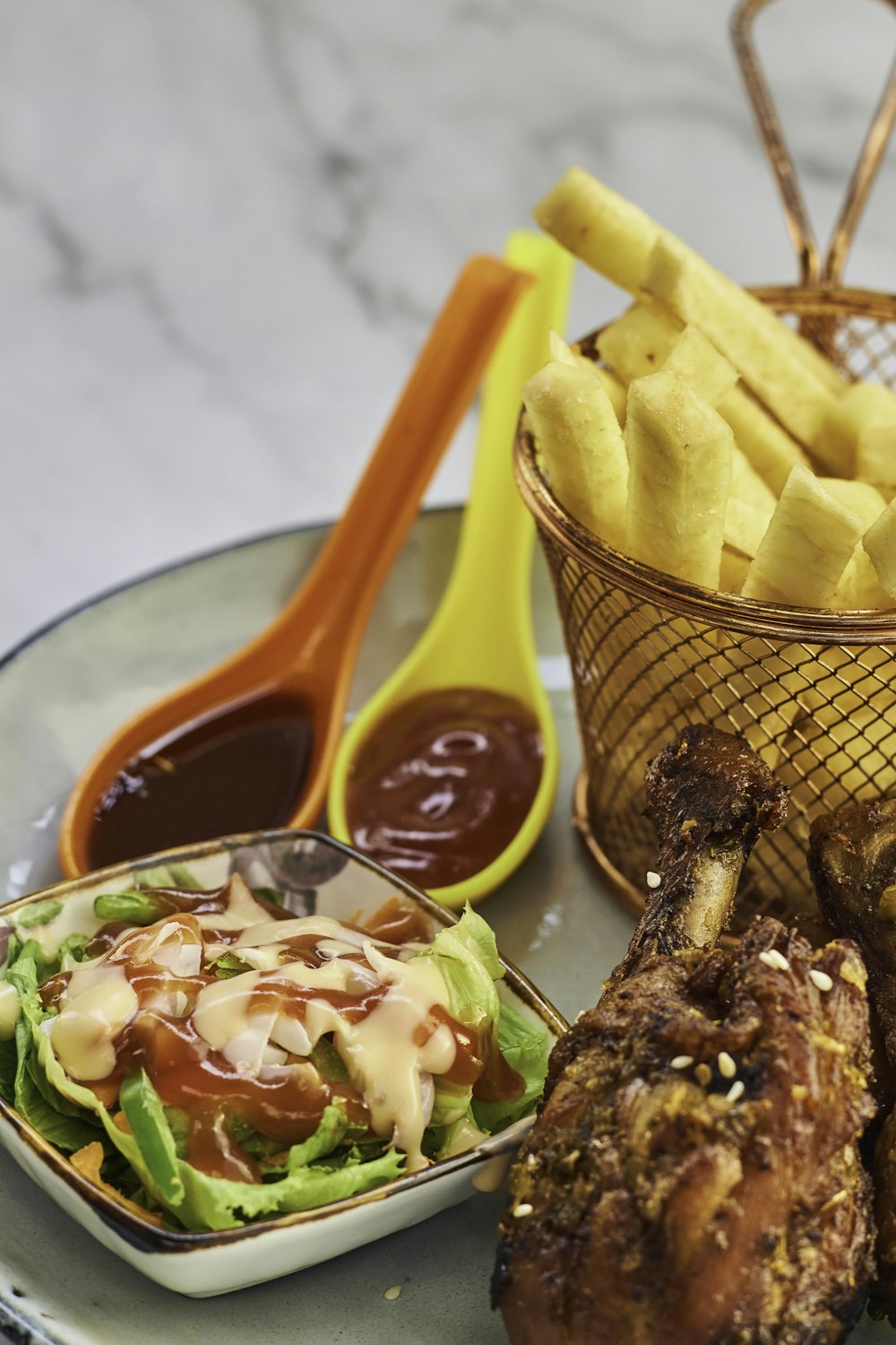 a plate of food with a basket of fries and a bowl of ketchup