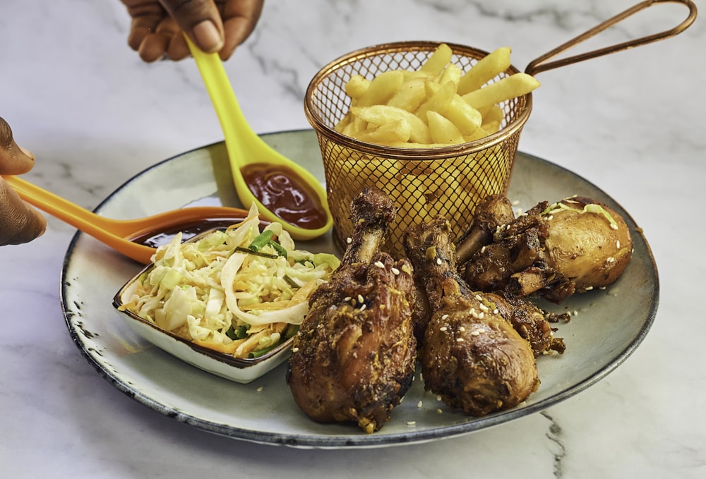 a plate of food that includes chicken, potatoes, and coleslaw