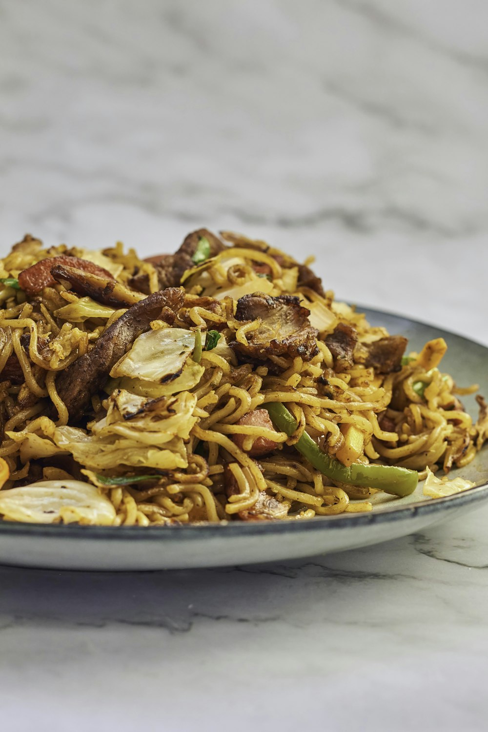 a plate of noodles with meat and vegetables