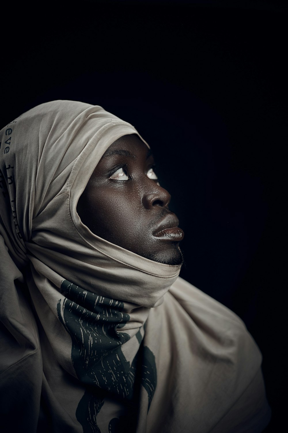 a woman in a headscarf looking up into the sky