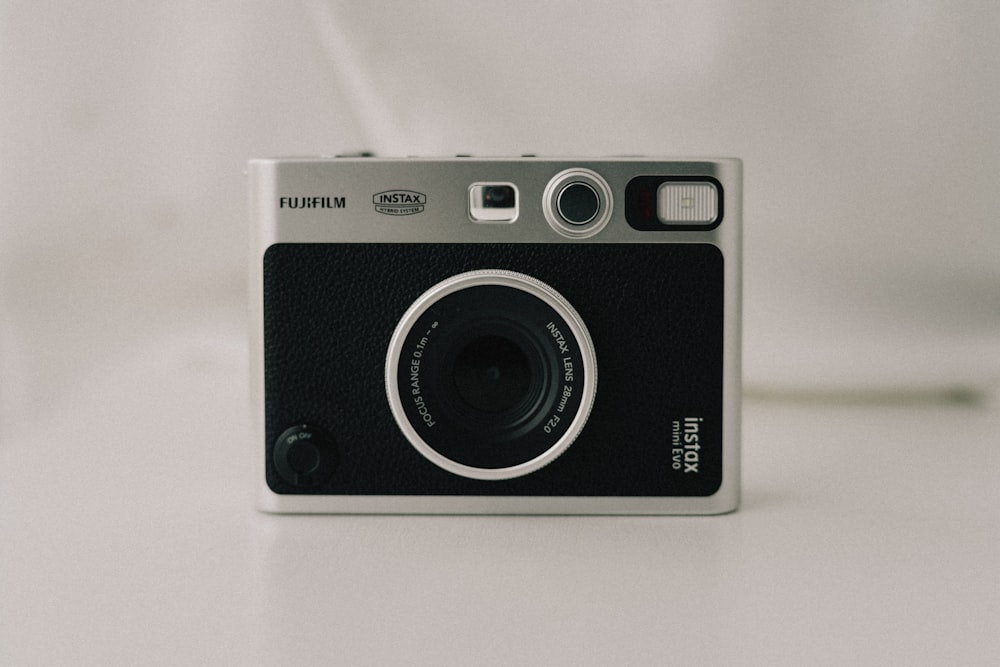 a black and silver camera sitting on top of a table