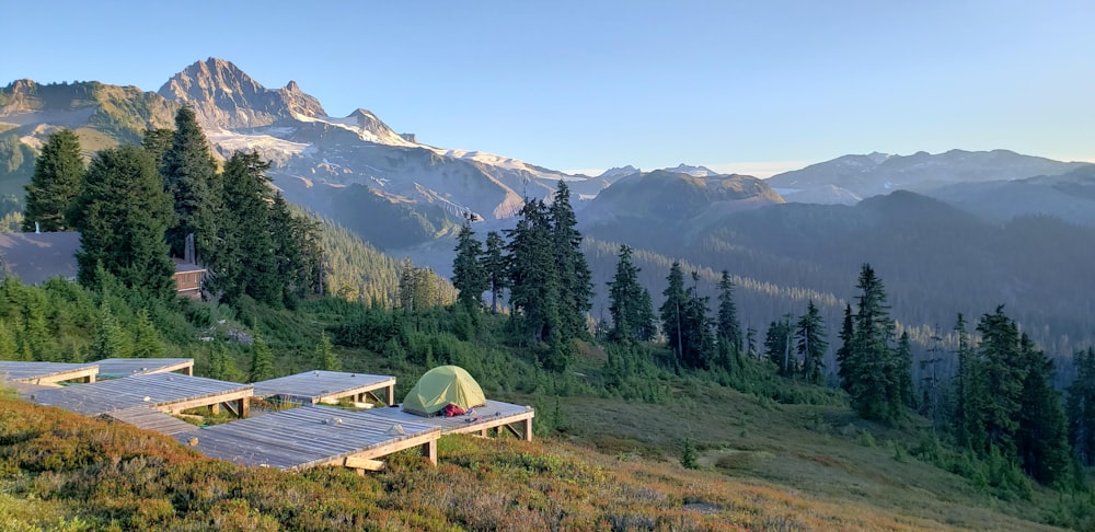 a tent set up on a wooden platform in the mountains