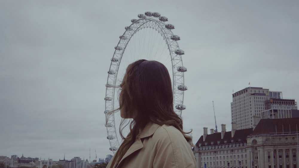 a woman standing in front of a ferris wheel