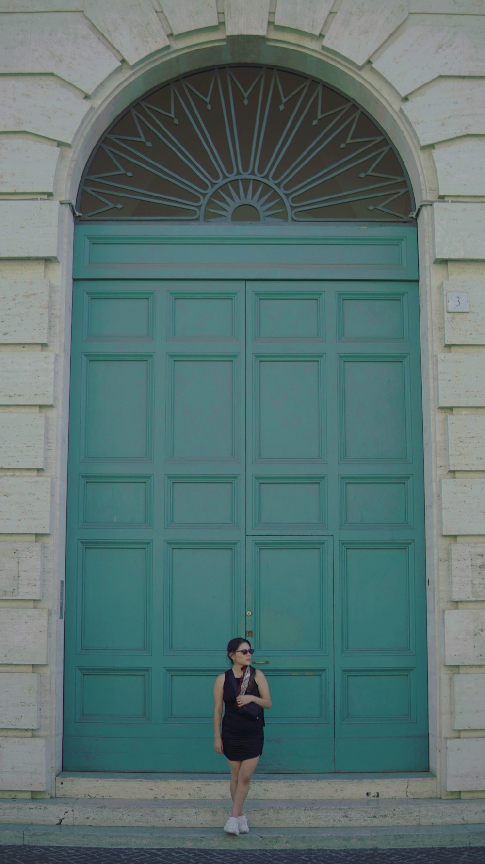 a woman standing in front of a green door