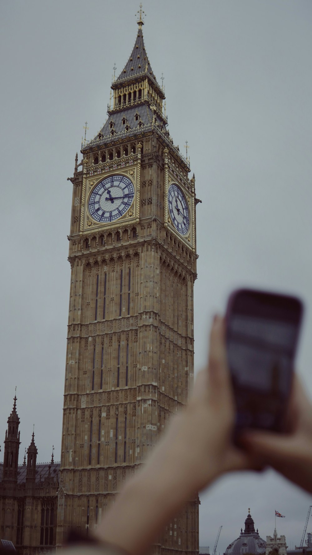 a person taking a picture of the big ben clock tower