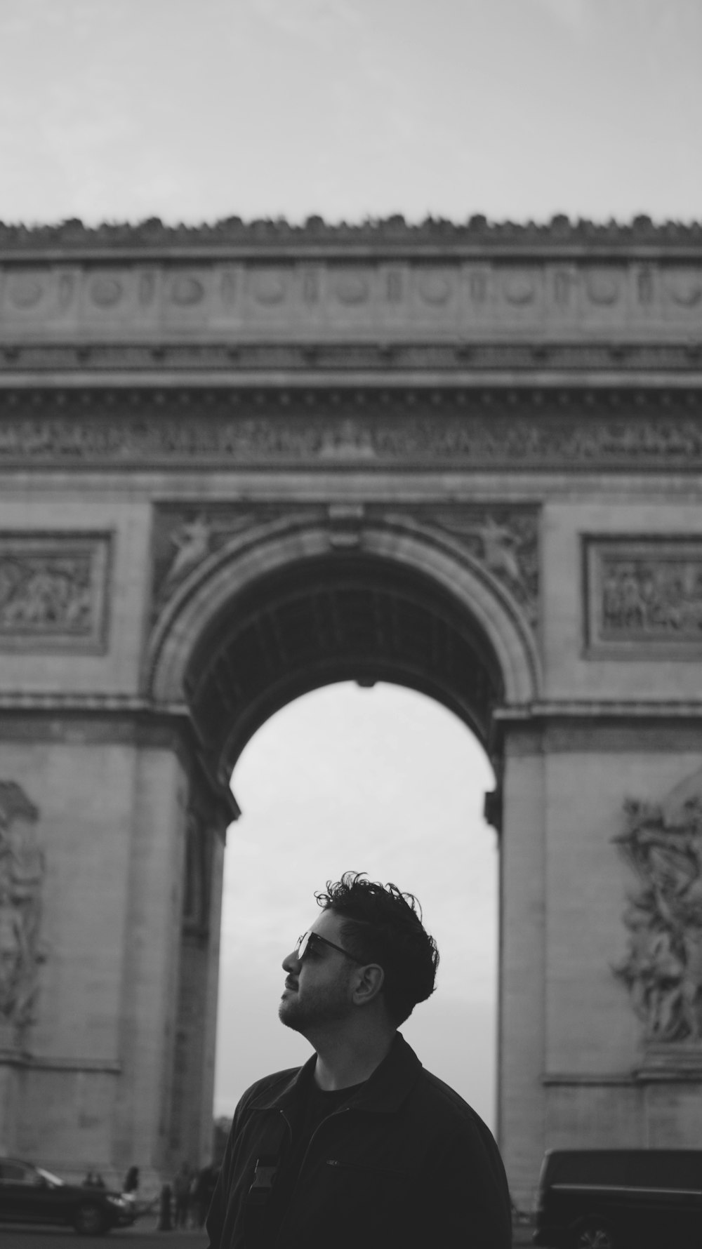 a man standing in front of the arc of triumph