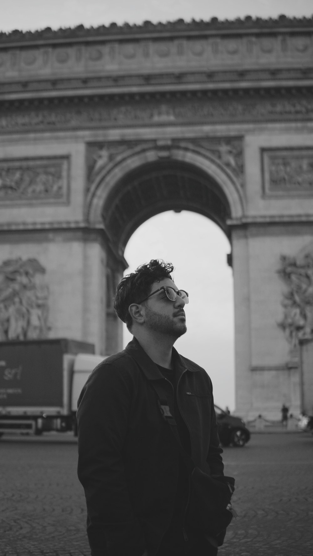 a man standing in front of the arc of triumph