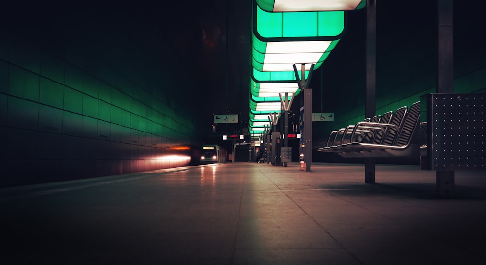 ein Bahnhof mit Bänken und Lichtern in der Nacht