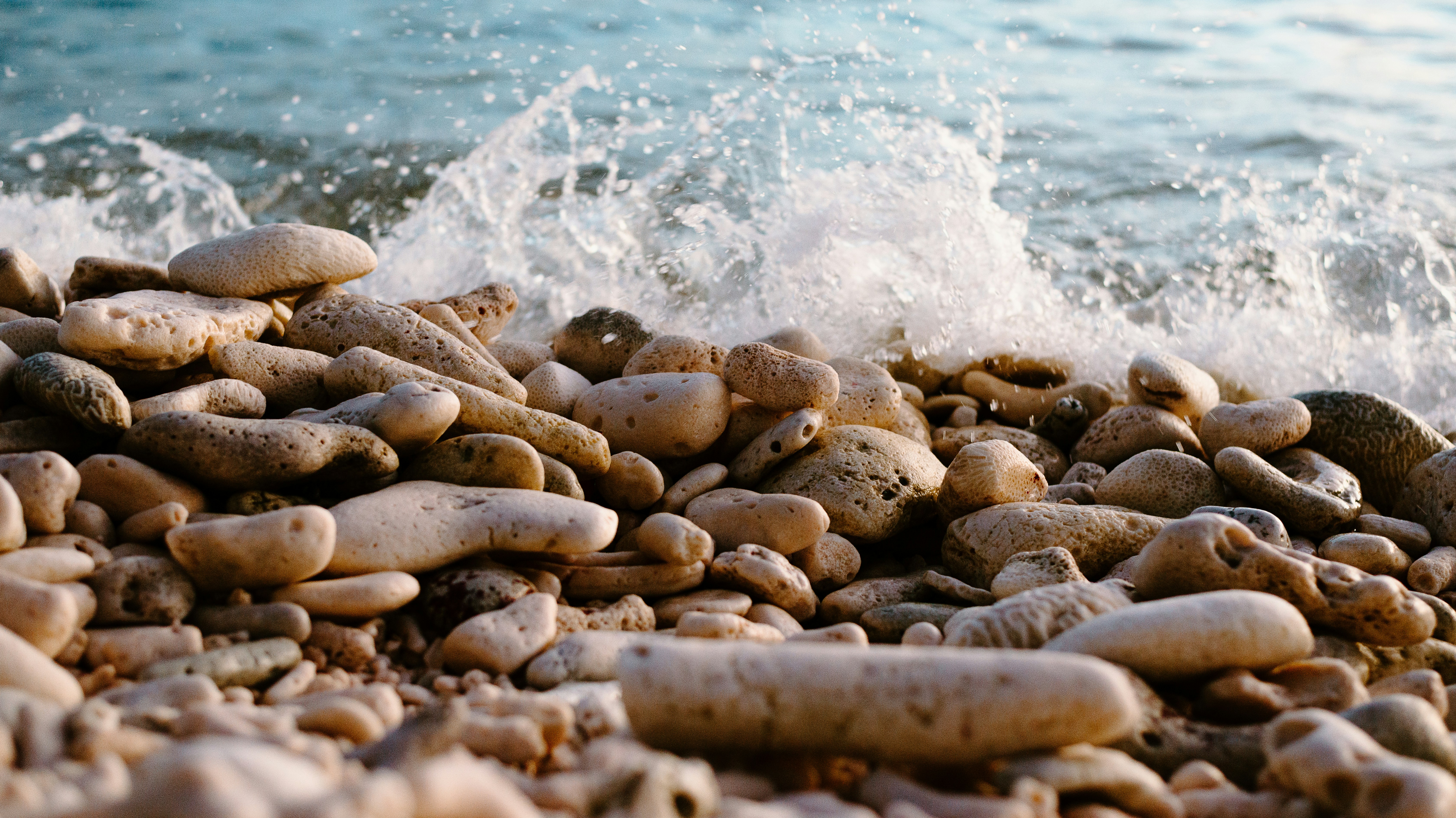 a pile of rocks sitting on top of a beach next to the ocean