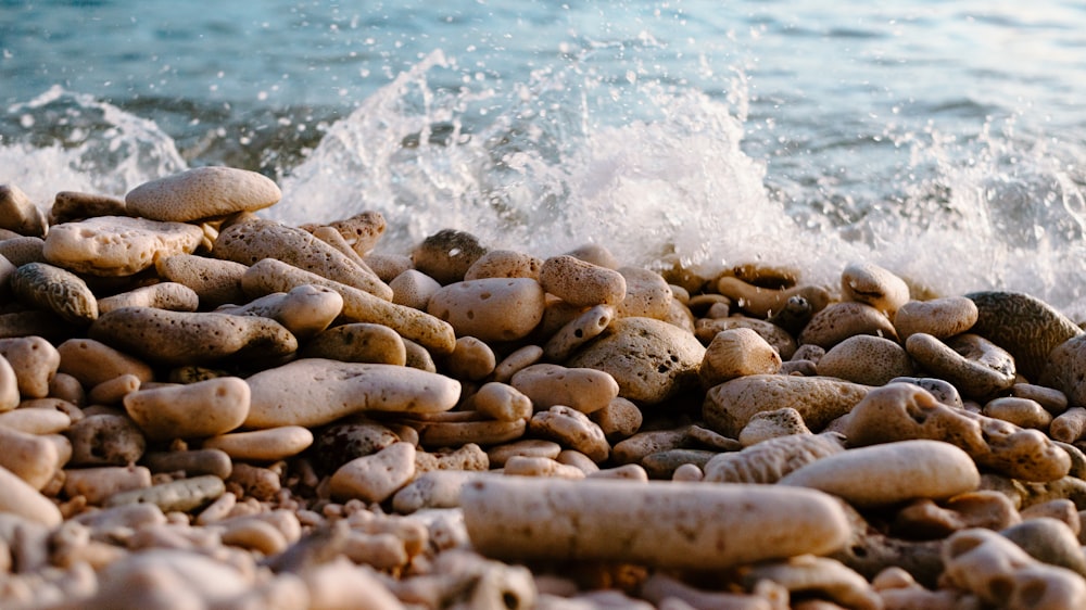 a pile of rocks sitting on top of a beach next to the ocean