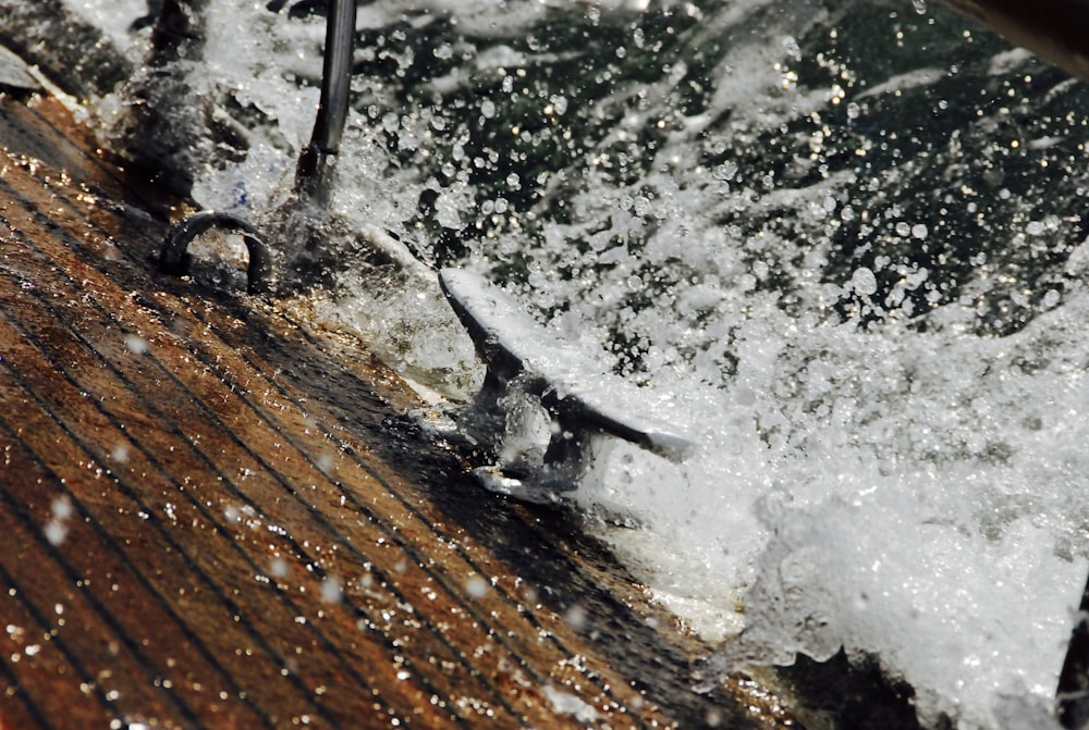 um close up de água espirrando em um deck de madeira