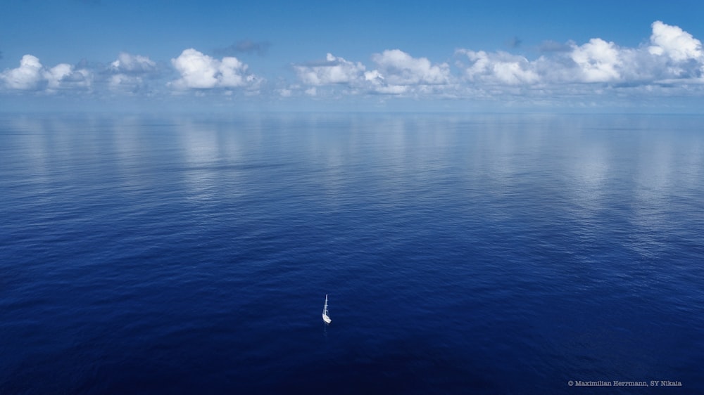 a small boat floating on top of a large body of water