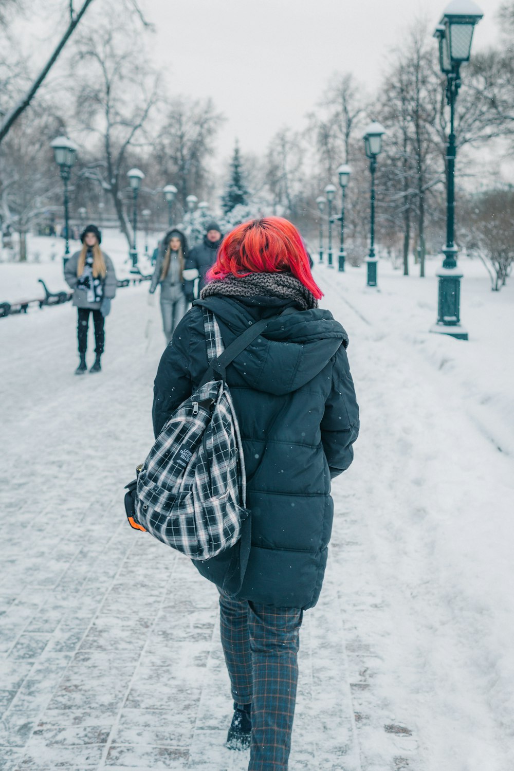 a woman with red hair walking in the snow