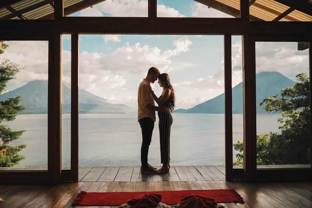 a man and a woman standing in front of a window